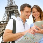 Tourists using electronic tablet in front of the Eiffel tower