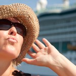 Beautiful Vacationing Woman on Tender Boat with Cruise Ship in the Background.