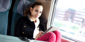 Young woman using tablet computer on the train