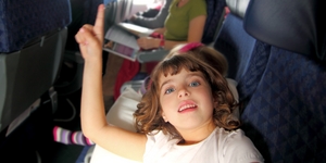 little girl inside aircraft rising up finger